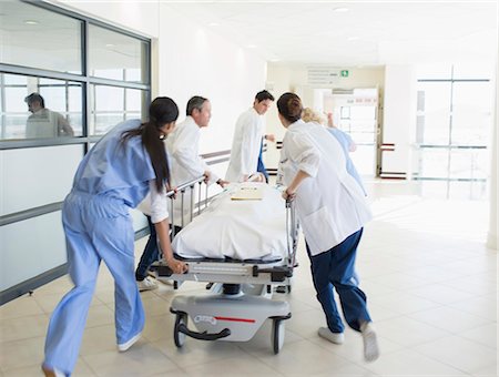 simsearch:6113-07762035,k - Doctors rushing patient on stretcher down hospital corridor Stock Photo - Premium Royalty-Free, Code: 6113-07146748