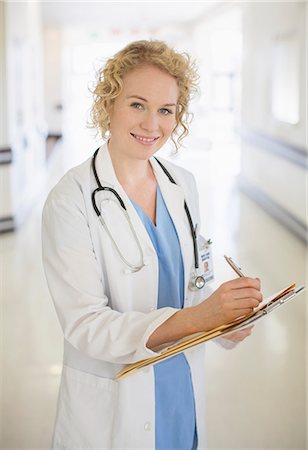 female doctor - Doctor writing on clipboard in hospital corridor Stock Photo - Premium Royalty-Free, Code: 6113-07146767