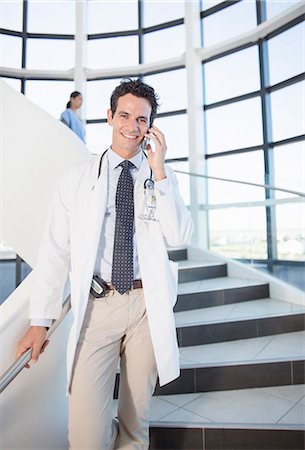 physicians walking front view - Doctor talking on cell phone in hospital Stock Photo - Premium Royalty-Free, Code: 6113-07146786