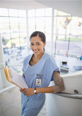 simsearch:6113-07146786,k - Portrait of smiling nurse on hospital staircase Fotografie stock - Premium Royalty-Free, Codice: 6113-07146790