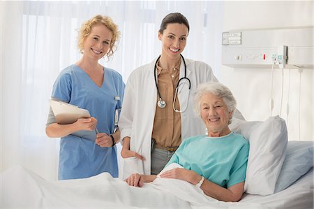 doctor scrubs patient smile - Doctor, nurse and senior patient smiling in hospital room Stock Photo - Premium Royalty-Free, Code: 6113-07146794