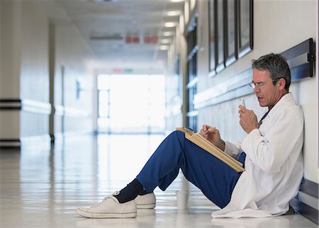 experto (hombre y mujer) - Doctor using dictaphone in hospital corridor Foto de stock - Sin royalties Premium, Código: 6113-07146798