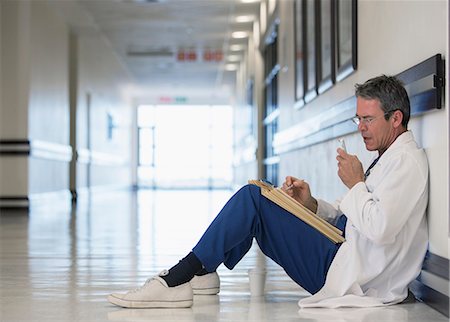 full body image of person in lab coat - Doctor using dictaphone in hospital corridor Stock Photo - Premium Royalty-Free, Code: 6113-07146798