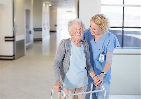 Nurse helping senior patient with walker in hospital corridor Photographie de stock - Premium Libres de Droits, Code: 6113-07146704