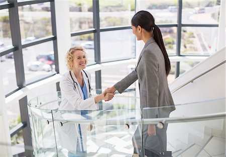 simsearch:6113-06497888,k - Doctor and businesswoman handshaking on stairs in hospital Stock Photo - Premium Royalty-Free, Code: 6113-07146711