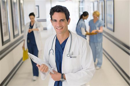 doctor eye contact - Portrait of smiling doctor in hospital corridor Stock Photo - Premium Royalty-Free, Code: 6113-07146730