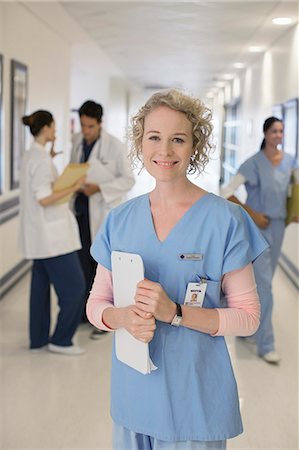 simsearch:6113-06908273,k - Portrait of smiling nurse in hospital corridor Fotografie stock - Premium Royalty-Free, Codice: 6113-07146739