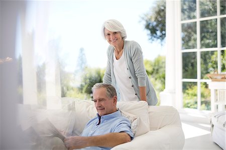 person reading a paper - Senior couple relaxing on patio sofa Stock Photo - Premium Royalty-Free, Code: 6113-07146868