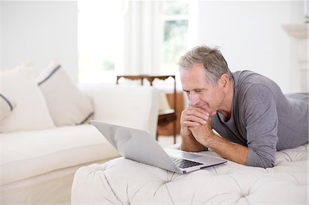 simsearch:6113-07146877,k - Senior man using laptop in livingroom Photographie de stock - Premium Libres de Droits, Code: 6113-07146882