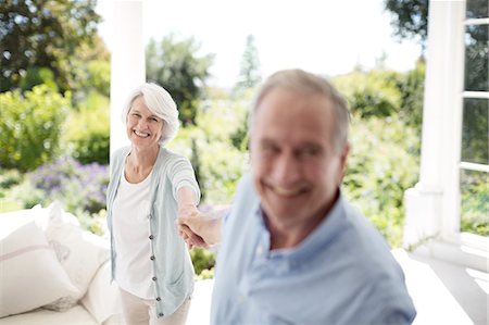 playful - Senior couple holding hands on patio Stock Photo - Premium Royalty-Free, Code: 6113-07146838