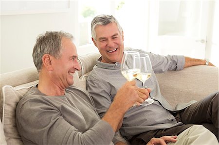 simsearch:6113-07146829,k - Senior men toasting wine glasses on sofa Foto de stock - Sin royalties Premium, Código: 6113-07146941