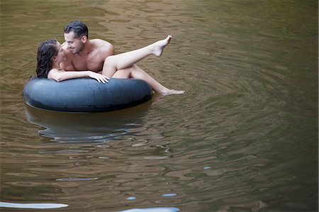 Couple playing in inner tube in river Photographie de stock - Premium Libres de Droits, Code: 6113-07147065