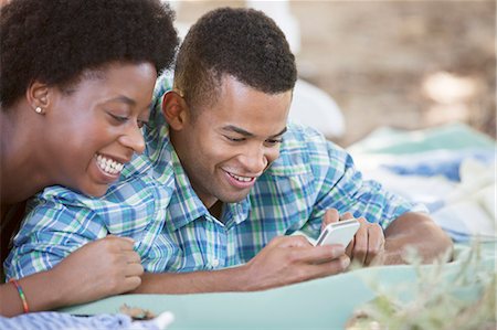 Couple using cell phone on blanket Stock Photo - Premium Royalty-Free, Code: 6113-07147072