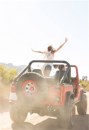 simsearch:6113-07147043,k - Woman cheering in sport utility vehicle on dirt road Stock Photo - Premium Royalty-Free, Code: 6113-07147090