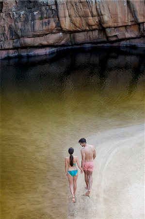 simsearch:614-07194675,k - Couple walking along pool Photographie de stock - Premium Libres de Droits, Code: 6113-07147092