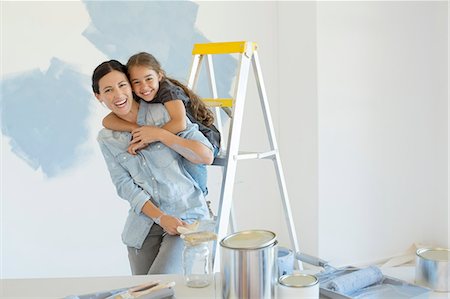 photos on wall - Portrait of mother and daughter hugging near paint supplies Stock Photo - Premium Royalty-Free, Code: 6113-07147154