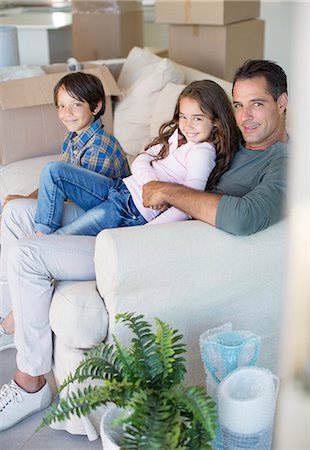 simsearch:6113-08947330,k - Father and children relaxing on sofa among cardboard boxes Foto de stock - Sin royalties Premium, Código: 6113-07147197