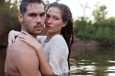 simsearch:6113-06908528,k - Portrait of serious couple hugging in river Stock Photo - Premium Royalty-Free, Code: 6113-07147115