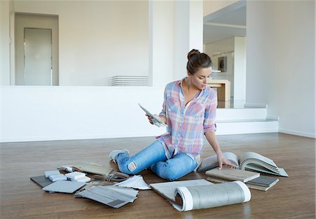 Woman viewing carpet and tile swatches on floor in new house Photographie de stock - Premium Libres de Droits, Code: 6113-07147134