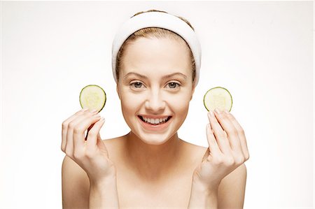 esthétique (traitement) - Smiling woman holding cucumber slices Photographie de stock - Premium Libres de Droits, Code: 6113-07147279