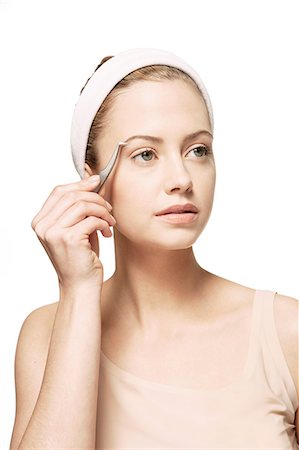 Woman plucking her eyebrows Stock Photo - Premium Royalty-Free, Code: 6113-07147283