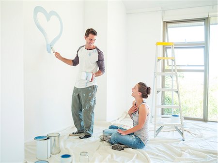 Woman watching man paint blue heart on wall Foto de stock - Sin royalties Premium, Código: 6113-07147212