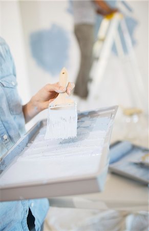 painting wall - Woman holding paint tray with blue paint Stock Photo - Premium Royalty-Free, Code: 6113-07147237