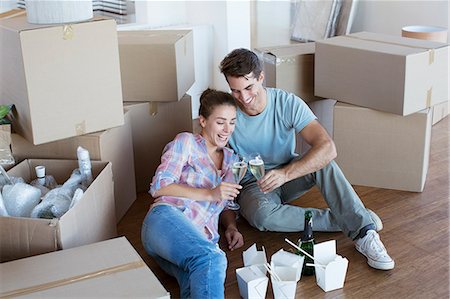 Couple enjoying champagne and Chinese take out food in new house Foto de stock - Royalty Free Premium, Número: 6113-07147236