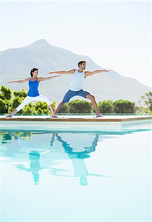 simsearch:6113-07147412,k - Couple practicing yoga at poolside Stock Photo - Premium Royalty-Free, Code: 6113-07147404