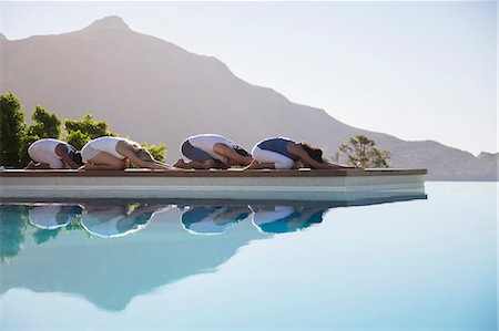 People practicing yoga at poolside Stock Photo - Premium Royalty-Free, Code: 6113-07147412