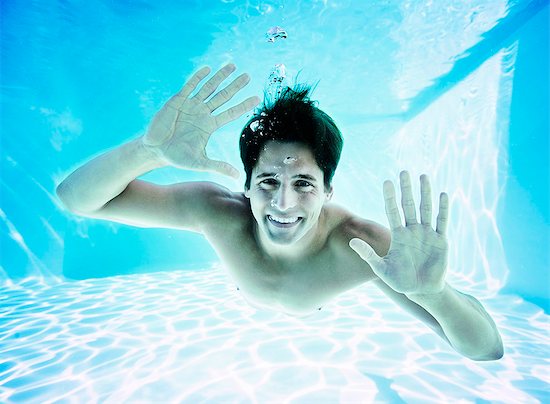 Portrait of man smiling underwater in swimming pool Stock Photo - Premium Royalty-Free, Image code: 6113-07147419