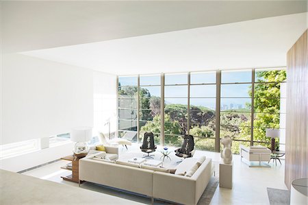 Modern living room overlooking trees Foto de stock - Sin royalties Premium, Código: 6113-07147563