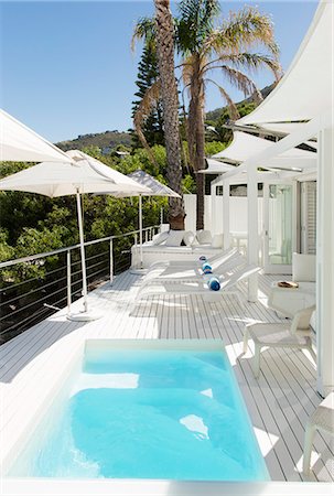 parasol de plage - Swimming pool and lounge chairs on patio Photographie de stock - Premium Libres de Droits, Code: 6113-07147503