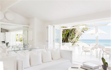 Modern living room overlooking beach and ocean Foto de stock - Sin royalties Premium, Código: 6113-07147510