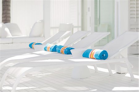Striped towels rolled up on white lounge chairs Photographie de stock - Premium Libres de Droits, Code: 6113-07147516