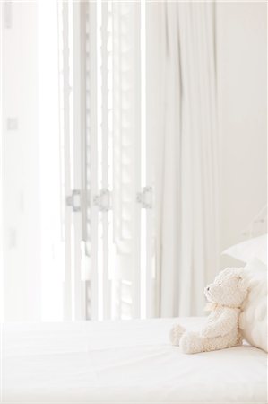 soft toy bed - Teddy bear on white bed Photographie de stock - Premium Libres de Droits, Code: 6113-07147519