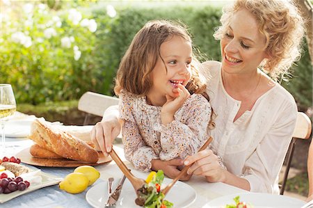 Mother and daughter eating in garden Stock Photo - Premium Royalty-Free, Code: 6113-07147647