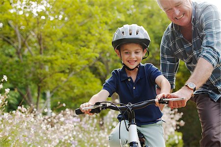 senior citizen outside copy space - Grandfather teaching grandson to ride bicycle Stock Photo - Premium Royalty-Free, Code: 6113-07147652