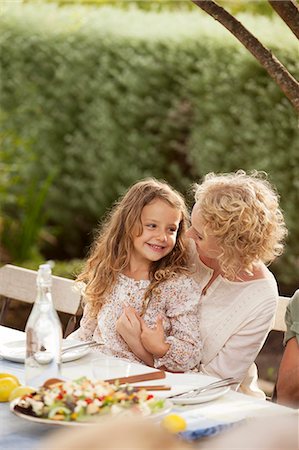 sitting on lap facing each other - Mother and daughter sitting at table outdoors Stock Photo - Premium Royalty-Free, Code: 6113-07147664