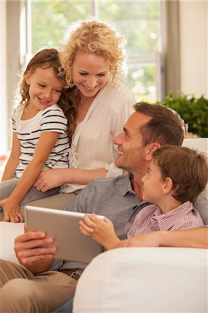 Family using digital tablet on sofa Photographie de stock - Premium Libres de Droits, Code: 6113-07147672