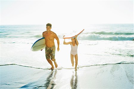 running father kid - Father and daughter carrying surfboard and bodyboard on beach Stock Photo - Premium Royalty-Free, Code: 6113-07147741