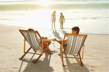 family on beach swimsuits - Parents watching daughters play in surf at beach Photographie de stock - Premium Libres de Droits, Code: 6113-07147742