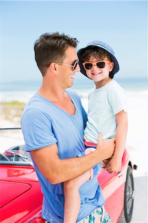 simsearch:6113-07762127,k - Father and son smiling on beach next to convertible Foto de stock - Sin royalties Premium, Código: 6113-07147763