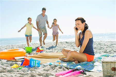 people talking on mobile phone - Woman talking on cell phone at beach Stock Photo - Premium Royalty-Free, Code: 6113-07147779