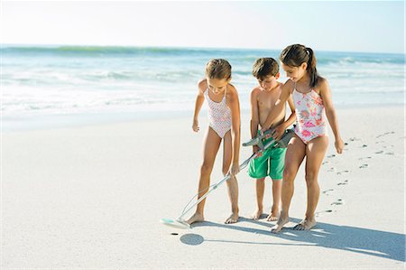 summer beach shorts - Children using metal detector on beach Stock Photo - Premium Royalty-Free, Code: 6113-07147791