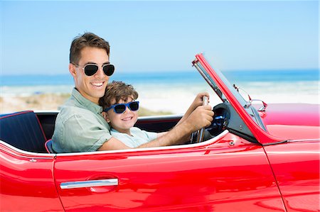 Father and son driving convertible on beach Photographie de stock - Premium Libres de Droits, Code: 6113-07147792