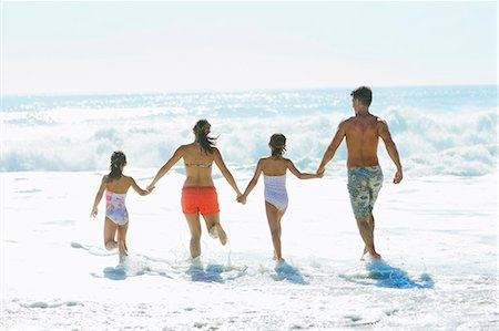 family beach photo - Family running into surf at beach Stock Photo - Premium Royalty-Free, Code: 6113-07147716