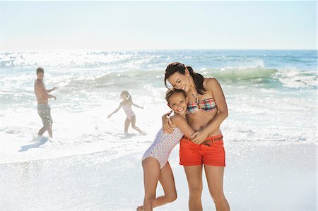 embrace couple swim suit - Mother and daughter hugging on beach Stock Photo - Premium Royalty-Free, Code: 6113-07147726