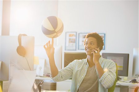 pic of office talking in phone - Businessman spinning basketball on finger in office Stock Photo - Premium Royalty-Free, Code: 6113-07147847