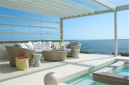 simsearch:6113-07147559,k - Sofa and chairs by swimming pool overlooking ocean Photographie de stock - Premium Libres de Droits, Code: 6113-07147809